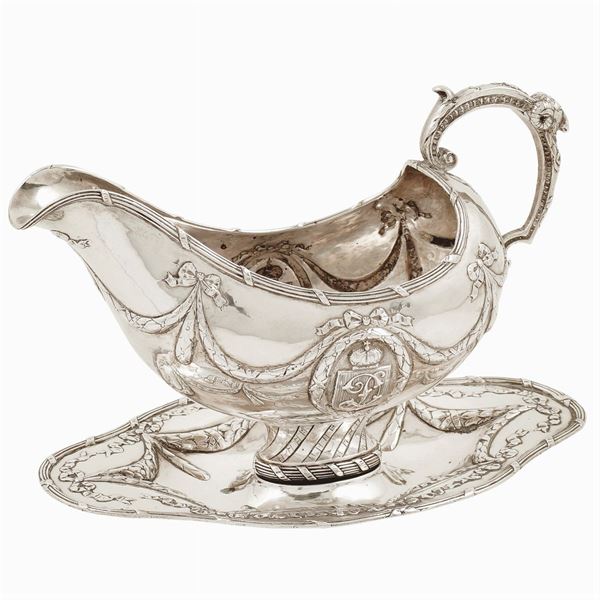 A silver sauce boat with oval tray
