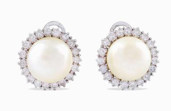 A pair of white gold earrings with two pearls