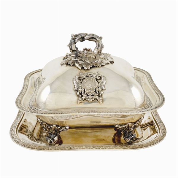 A silver tureen with its presentoire