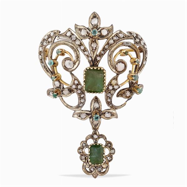 A gold and silver brooch with emeralds