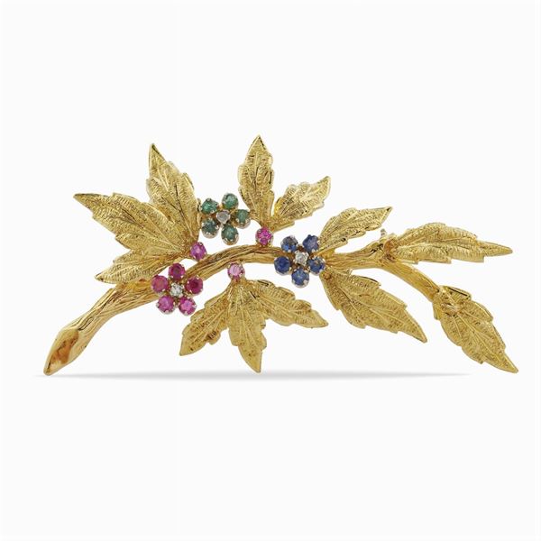 A gold brooch featuring a flower