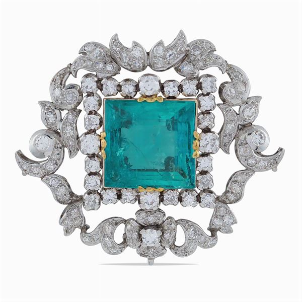A platinum and rose gold brooch with emerald