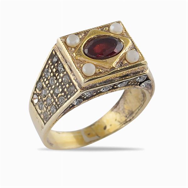 A gold and silver ring with garnet