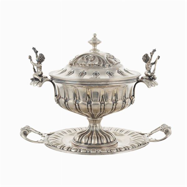 A silver soup tureen with presentoire