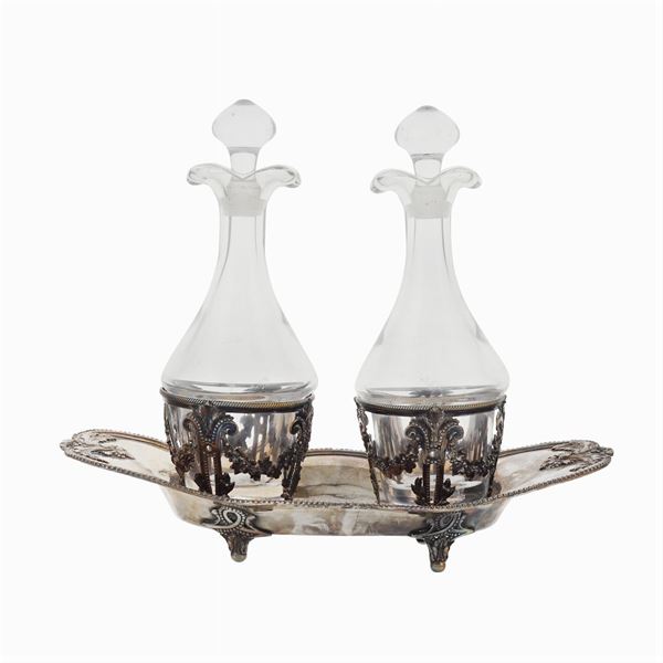 A silver and glass oil jug with two ampules