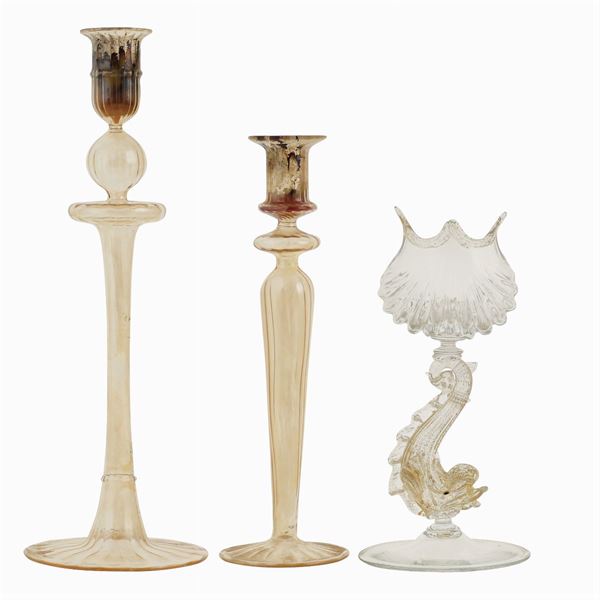 A group of 3 candlesticks in transparent and gold glass