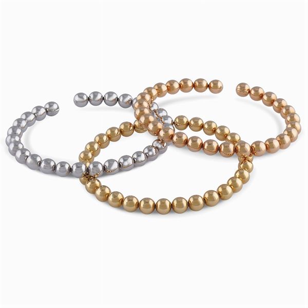 Tre bracciali a manetta in oro a tre colori 18kt