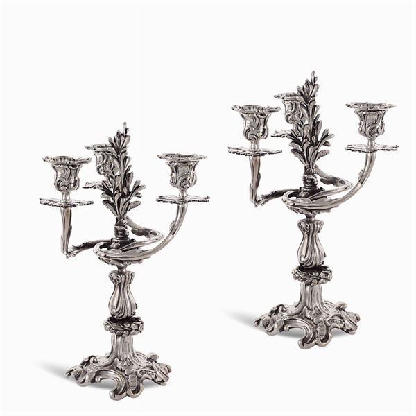 Coppia di candelabri in metallo argentato a tre fiamme