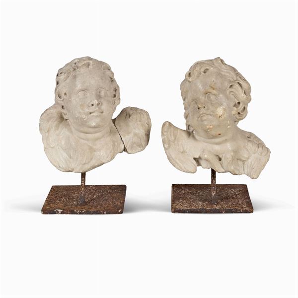 Two white marble putti heads