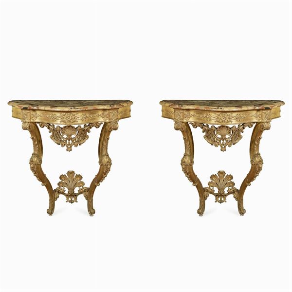 Coppia di consoles in legno dorato ed intagliato