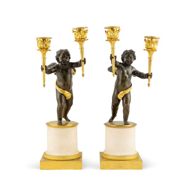 Pair of patinated and gilded bronze candlesticks