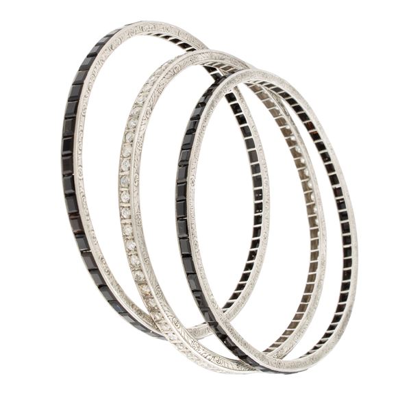 Tre bracciali a manetta in platino onice nero e diamanti