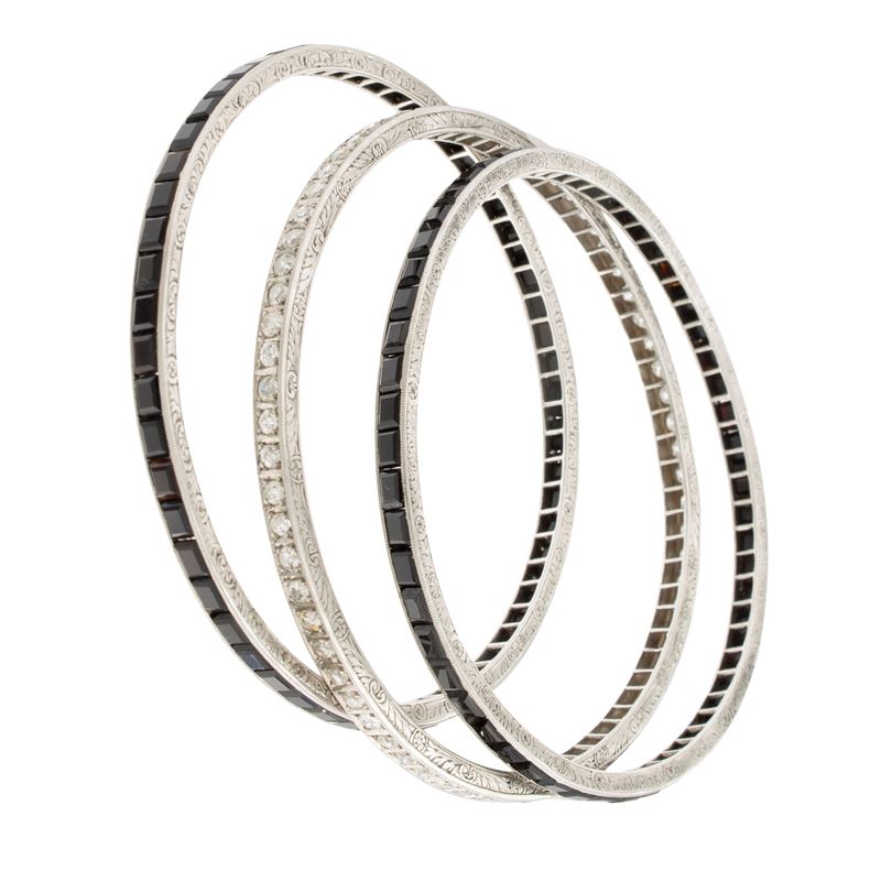 Tre bracciali a manetta in platino onice nero e diamanti