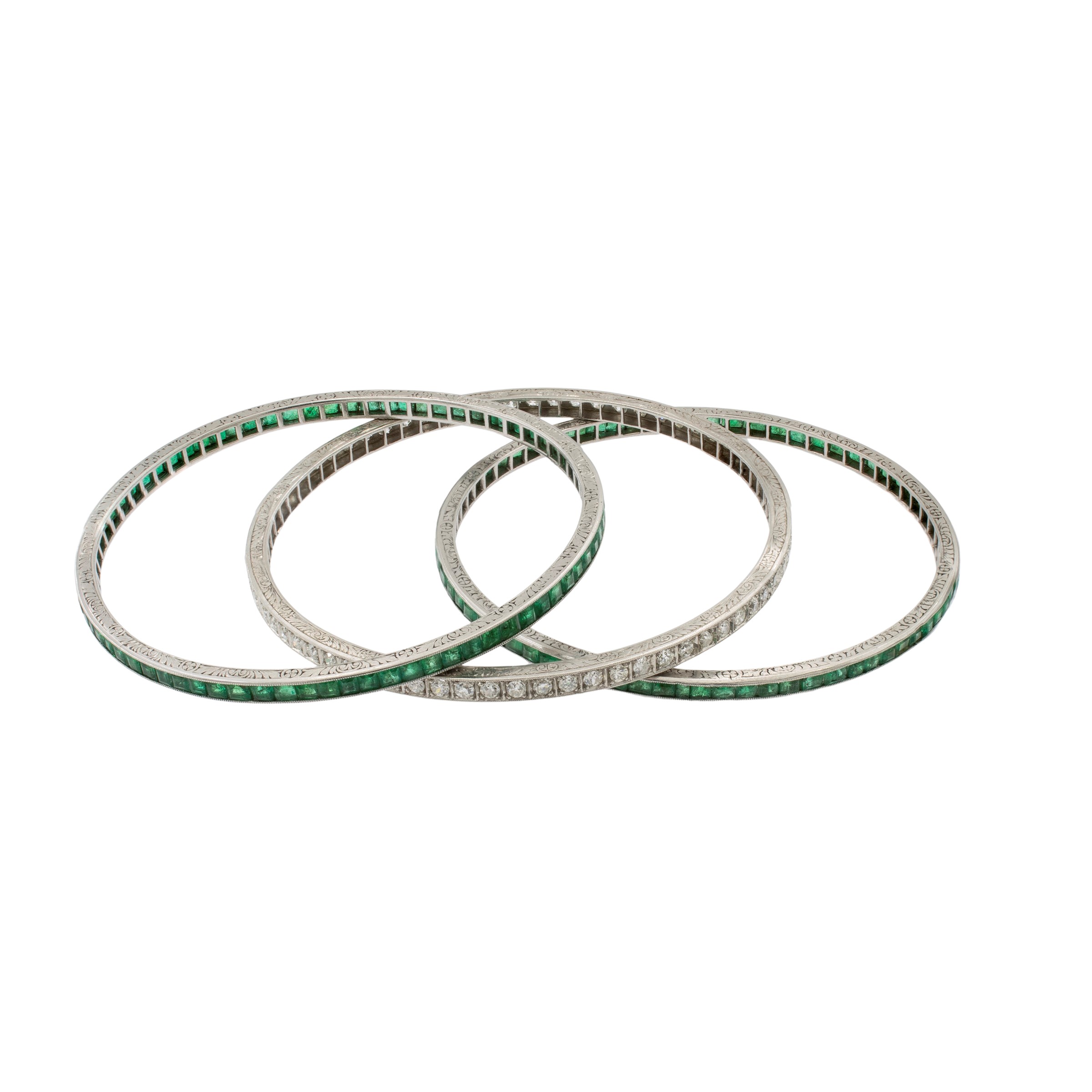 Tre bracciali a manetta in platino smeraldi e diamanti