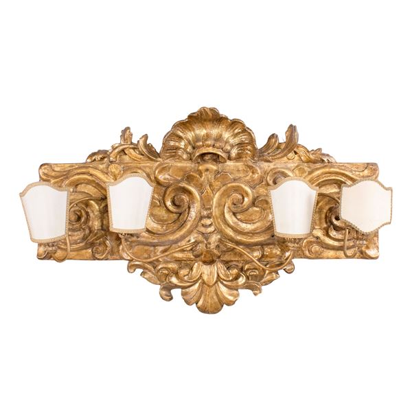 Fregio elettrificato in legno dorato ed intagliato a quattro luci