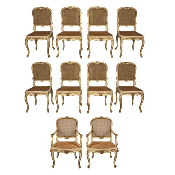 Two armchairs and eight lacquered wooden chairs, golden and carved