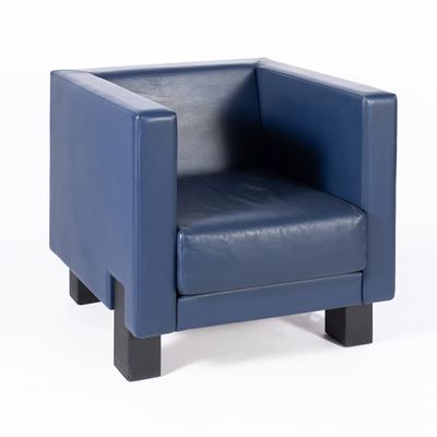 Poltrona “Moji” in pelle imbottita e legno verniciato